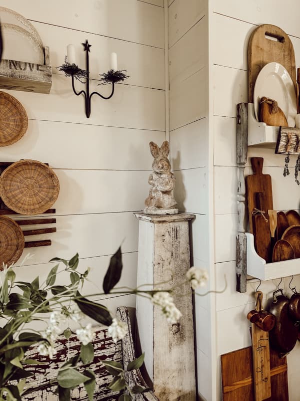 Bring concrete statuaries indoors concrete bunny on old wooden porch post. 