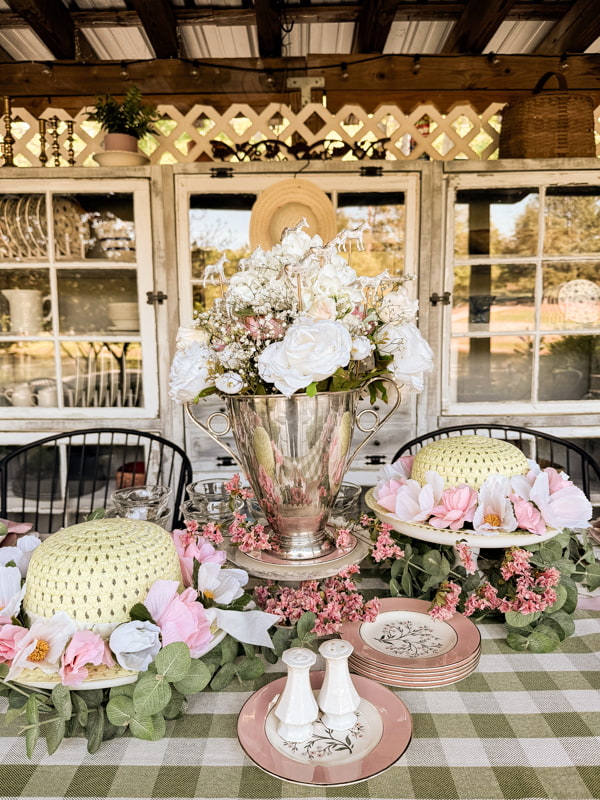 Roses and hydrangeas fill the silver trophy vase and Dollar Tree hats with roses.  