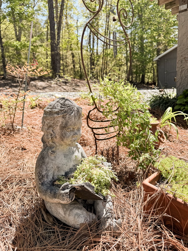 Vintage Concrete Statuary  girl with book planters in garden beside outdoor kitchen