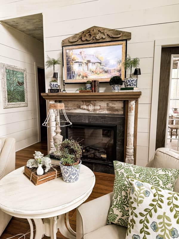 LIving Room with Blue and Green Pillows  & Blue and White Spring Mantel with old books and vintage brass candlestick holders. 