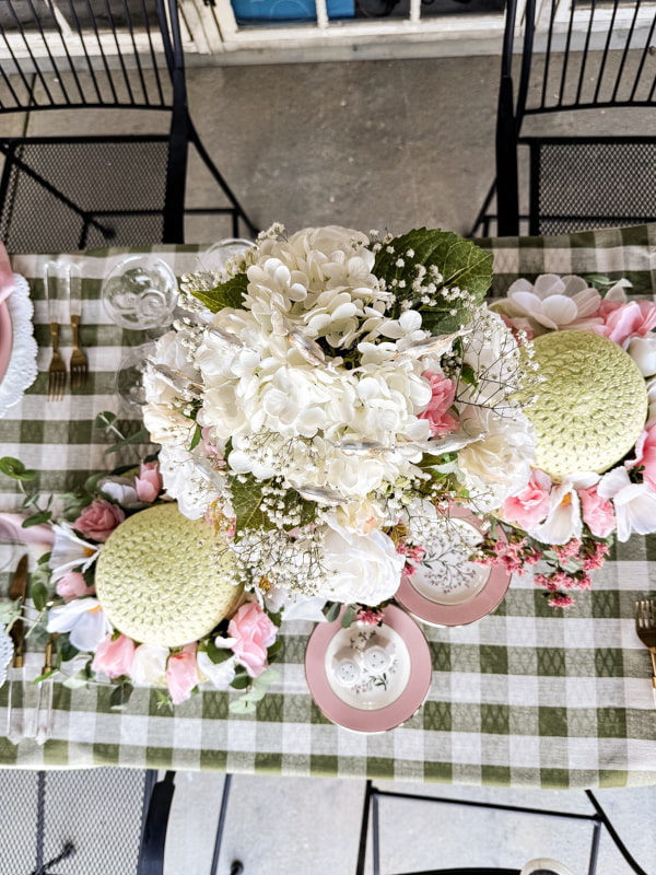 Kentucky Derby Tablescape with decorative hats and silver trophy centerpiece with roses and hydrangeas,