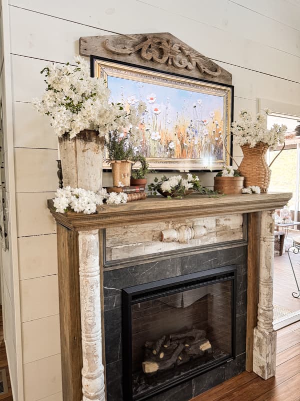 Vintage Springtime mantel decor with white azaleas and rosemary.  Vintage sap bucket and old basket vase.  