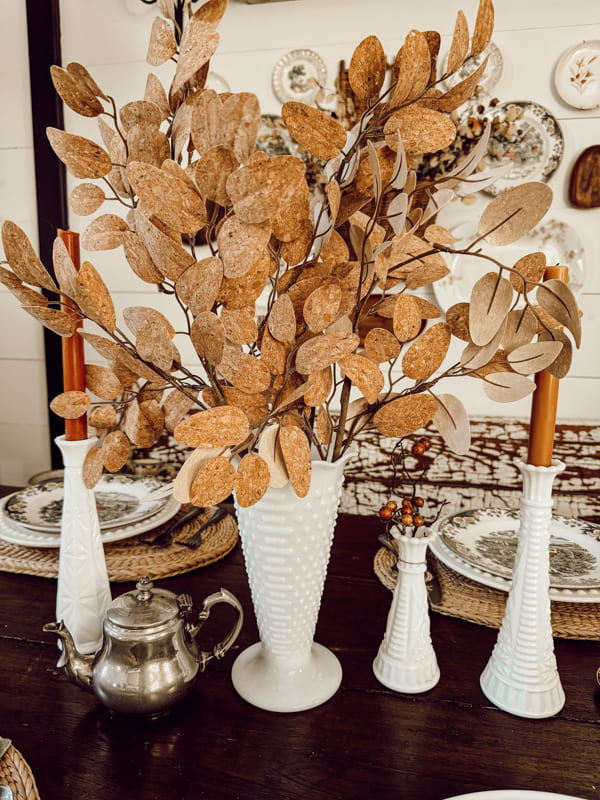white milk glass vases with fall stems and candles