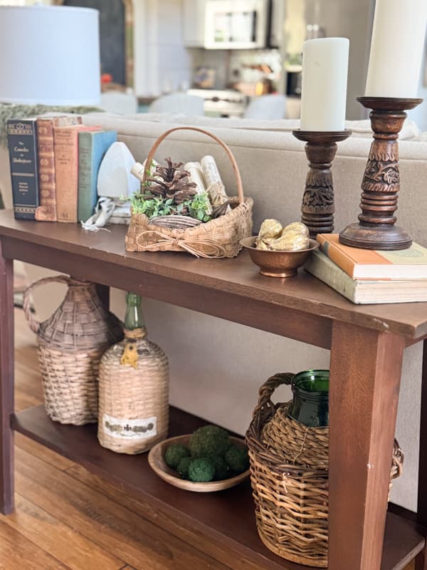3 demijohns on bottom shelf of sofa table