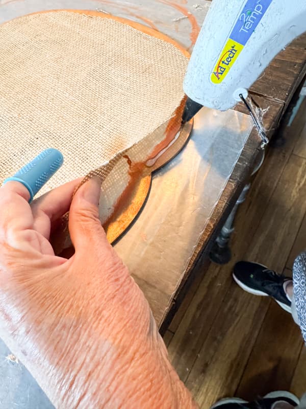 Add hot glue to attach burlap pumpkin to wood