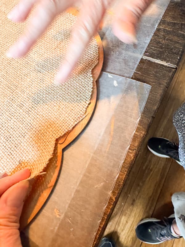 Add burlap fabric to wood pumpkin with hot glue