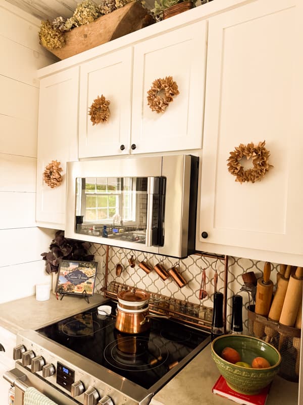 mini faux corn husk wreath on kitchen cabinet doors