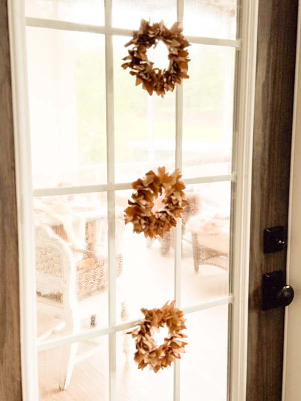 3 mini fall wreaths on glass door.