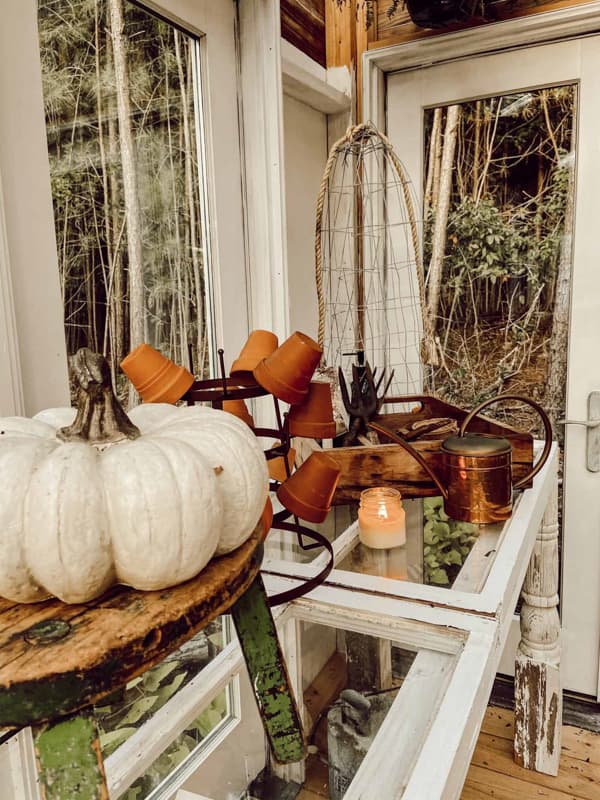 old copper watering can with pumpkin on thrift store stool