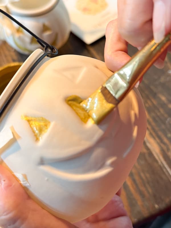 Paint the eyes and nose with gold leaf paint