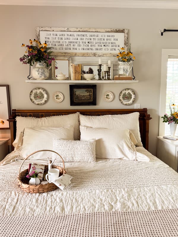 repurposed mantel above bed with thrift store finds and garden flowers decorated for fall