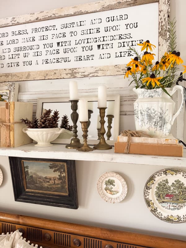 Repurposed mantel with brass candlestick holders and transferware pitcher with black eyed susans
