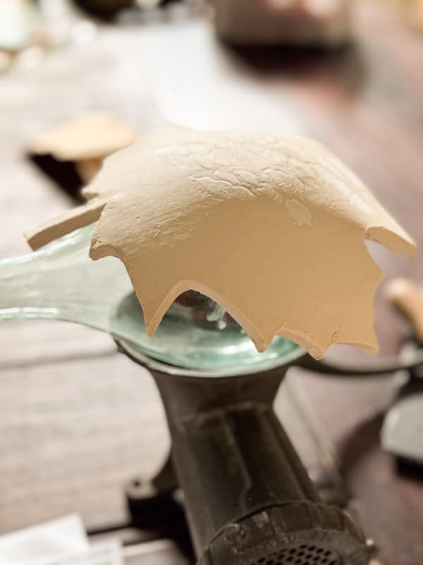 shape air dry clay leaf over glass bottle to dry