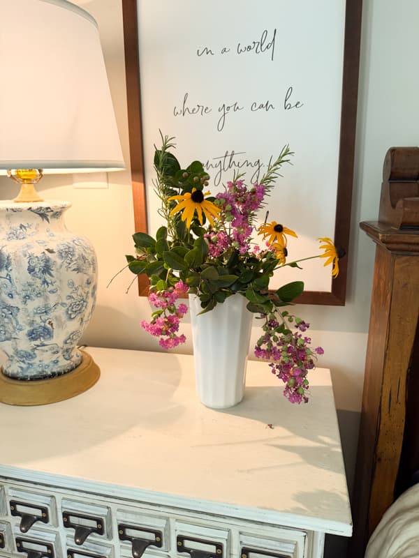 side table with milk glass vase filled with garden flowers.