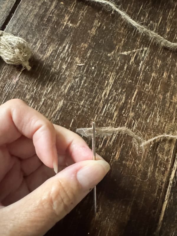 use tape to thread the needle with jute twine