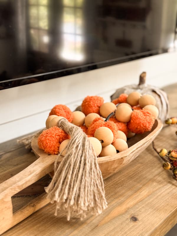 DIY pumpkin and bead garland in small dough bowl