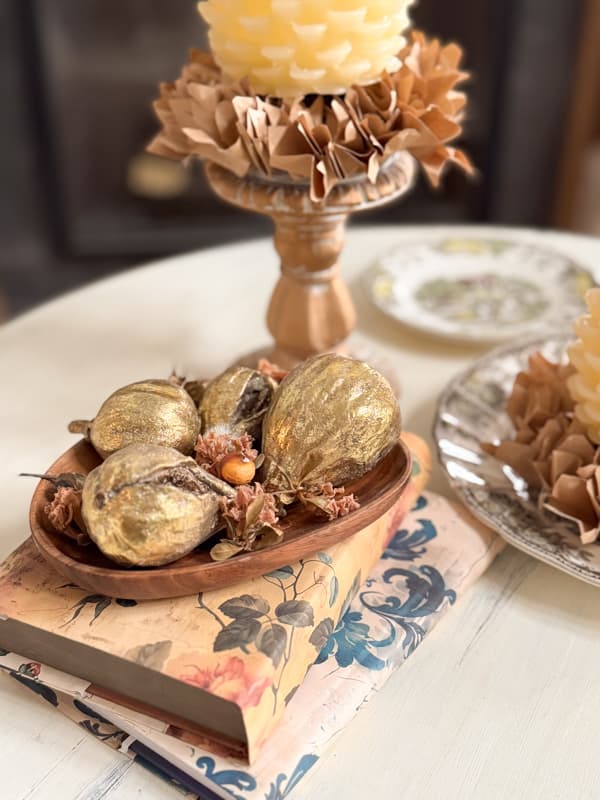 Gold Decorative figs in wooden bowl on side table