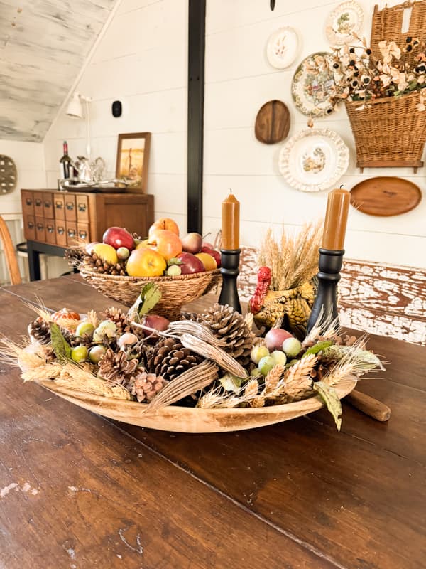 Vintage bowl filled with gathered fall element and bowl of fruit