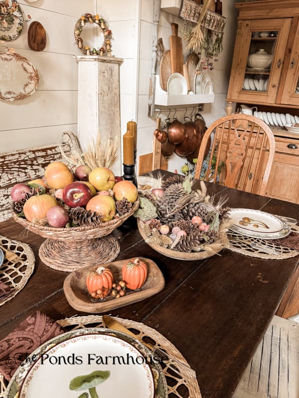 Thrifted woven basket with apples and pinecones.