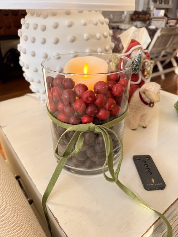 nuts and berries filled large vase with flicker candle
