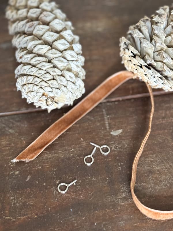 Adding ribbon to bleached pinecones
