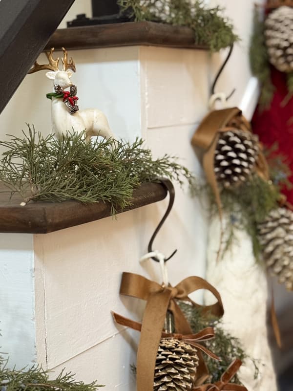 reindeer on stair treads with cedar and pinecone adorned Christmas stockings