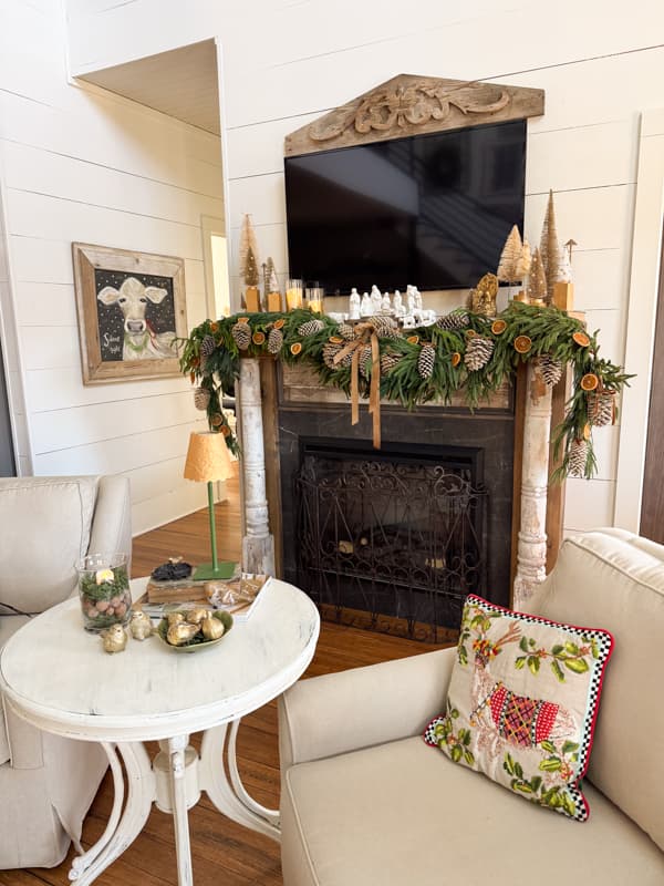Living Room with side chair and mantel decorated for 2025 Christmas Tour