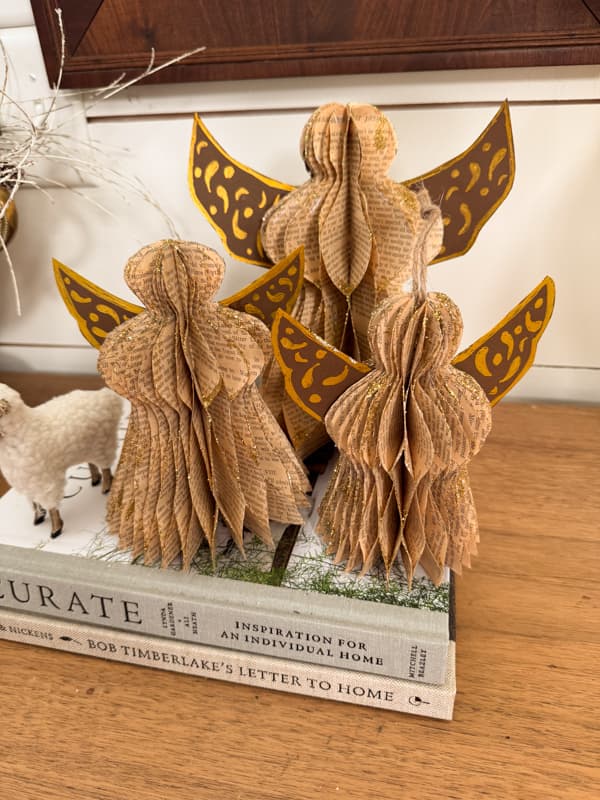 Paper angels with glitter on stack of books 