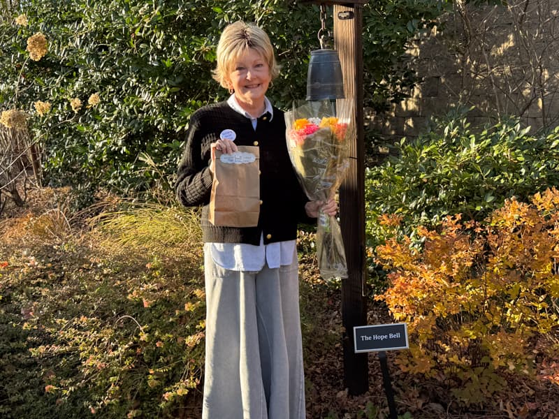 Rachel with roses and bundt cake at bell ringing ceremony
