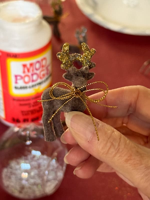 reindeer with glitter on antlers and gold metallic bow