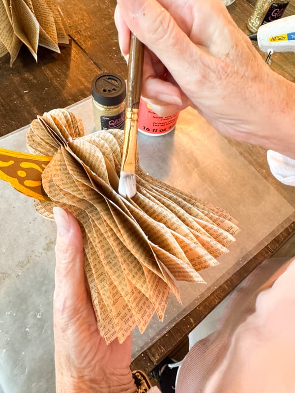 add glue to edges of angel with paintbrush