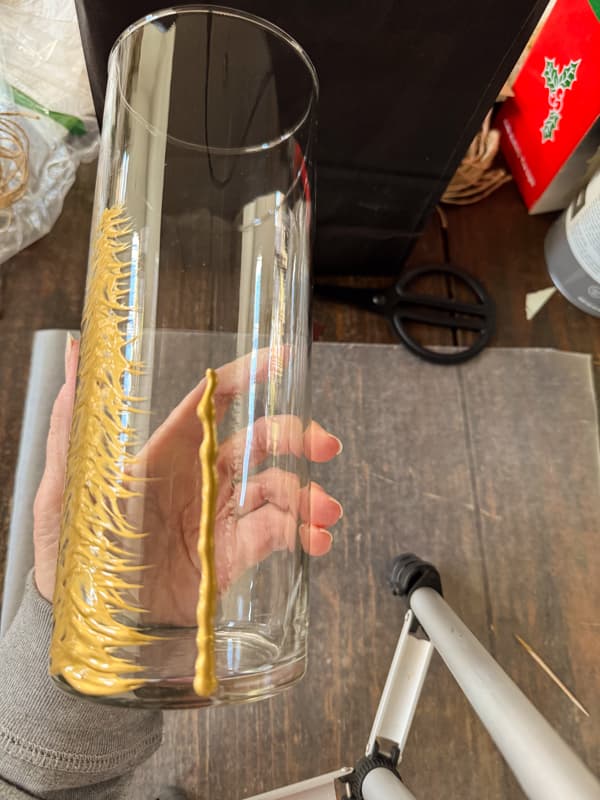 drraw a vertical line with gold paint on the glass vase