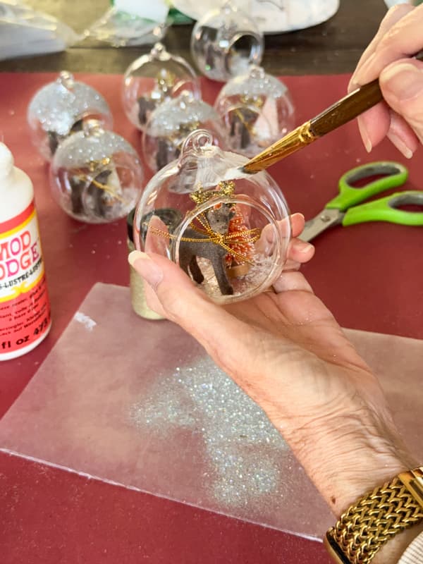 add mod podge to top of ornaments