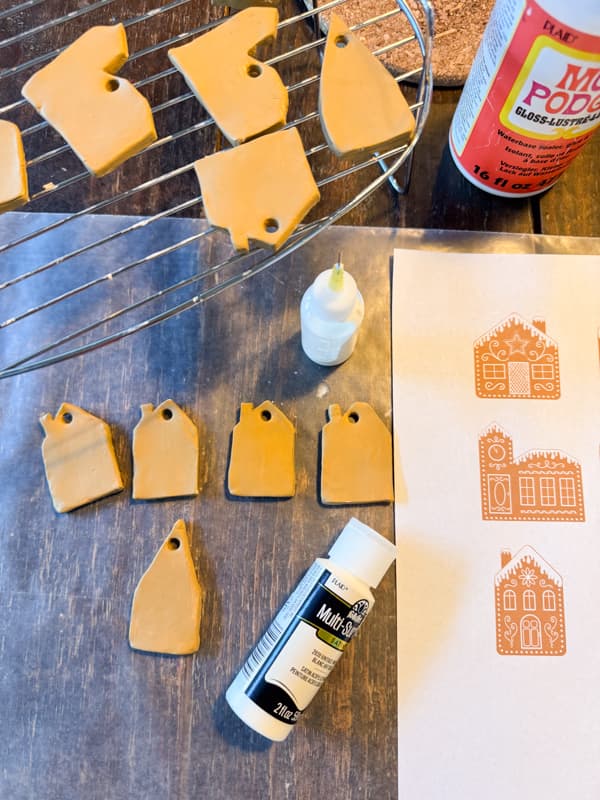 Prepare to paint details of gingerbread houses with white paint.