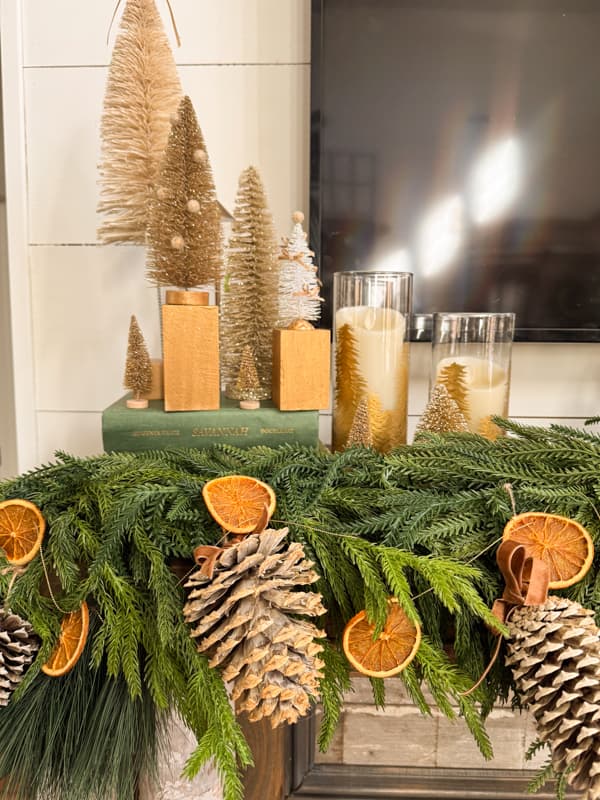 bottle brush trees and candle holders on rustic Christmas Mantel