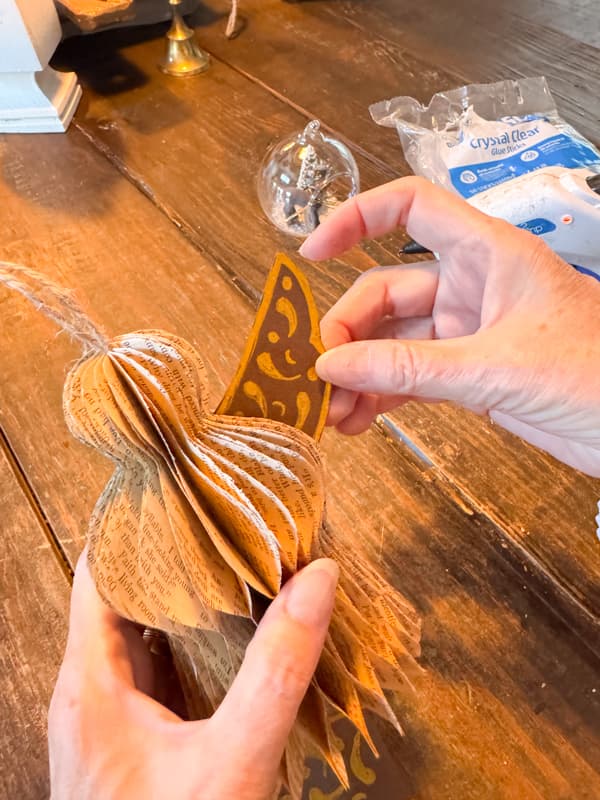 tuck angel wing into paper angel to adhere