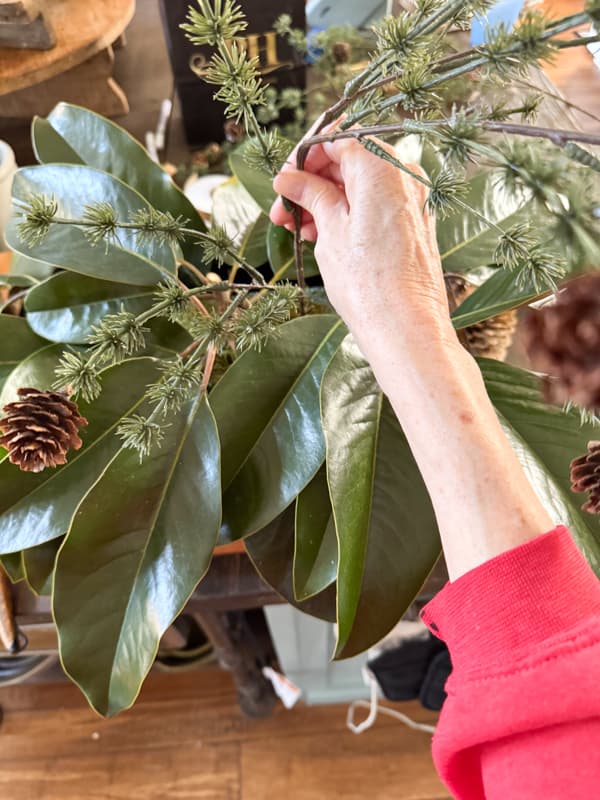 adding pine stems to centerpiece