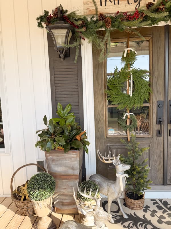 trio of wreath on front doors with planter and reindeer for Christmas Porch Decorations