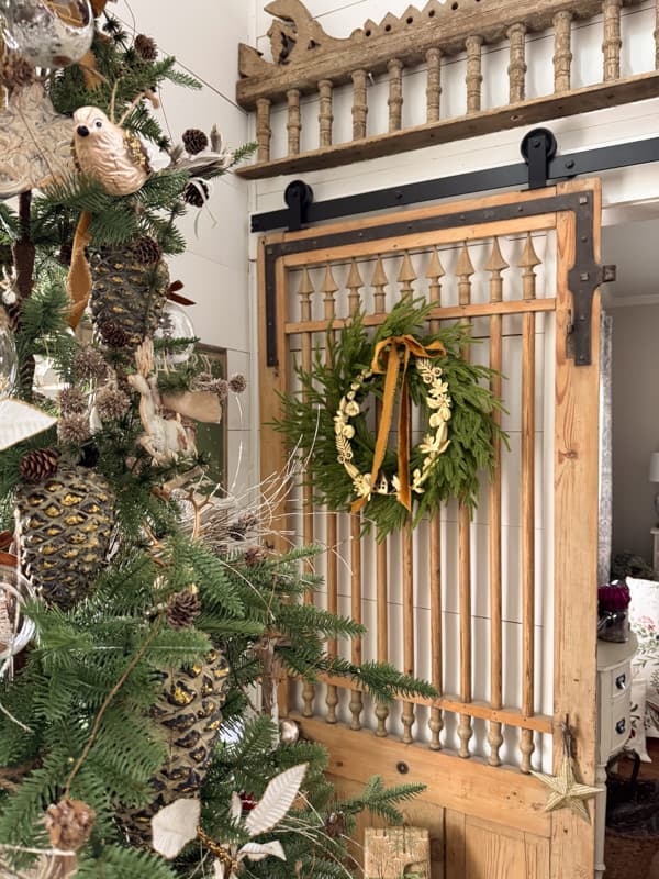 antique door repurposed into a barn door with Christmas Wreath