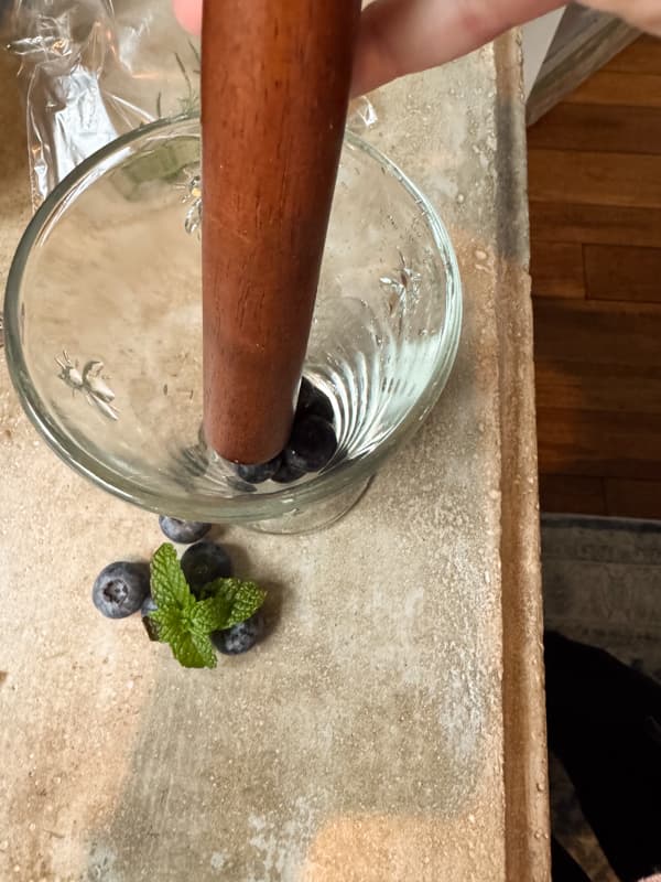 muddle blueberries and mint for blueberry mojito
