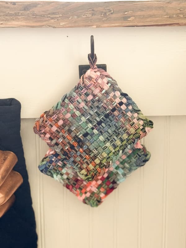 2 colorful DIY pot holders hanging on a hook