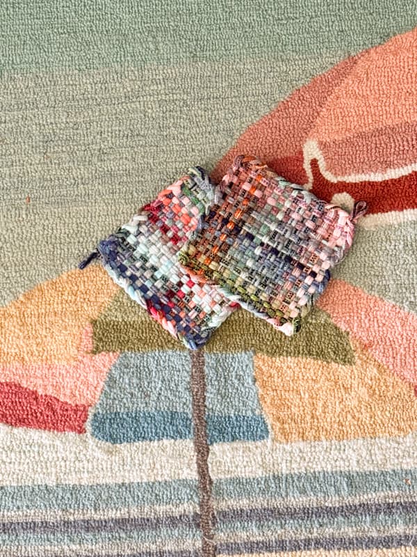 two colorful pot holders on coastal kitchen rug