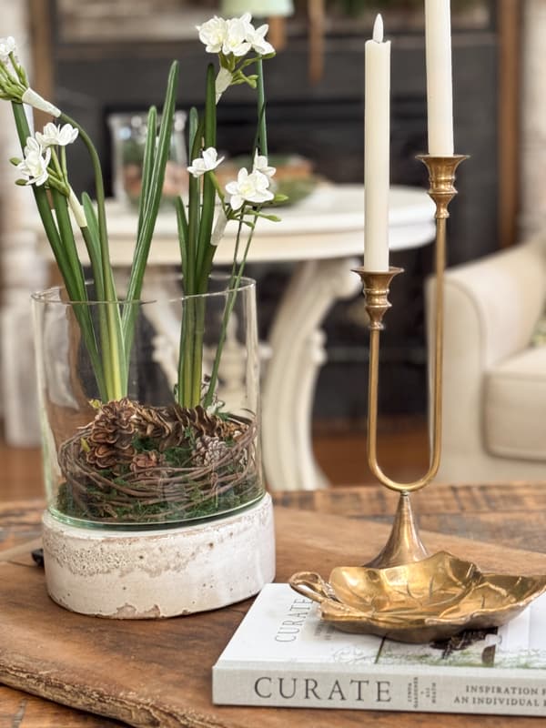 Coffee table with paperwhite arrangement and brass pieces for winter decorating