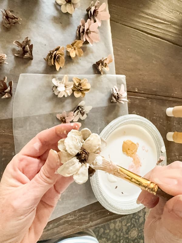 Painting the pinecone flower with Pink craft paing to make a flower heart wreath