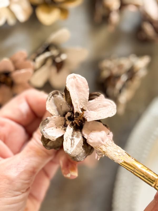 Painting the pinecone flower with Pink craft paing to make a flower heart wreath