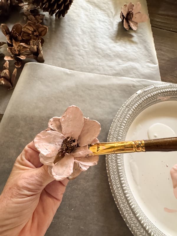 Painting the pinecone flower with Pink craft paing to make a flower heart wreath