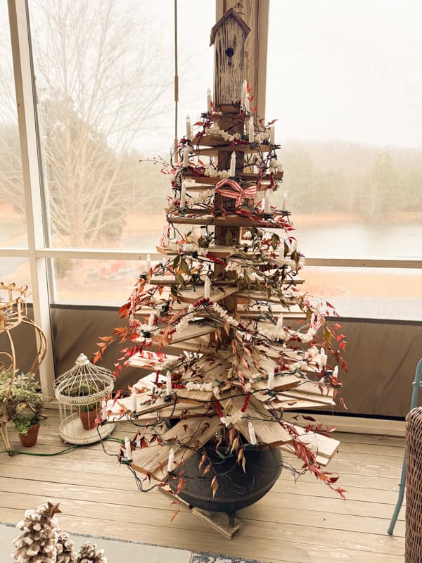 Shiplap tree on screen porch decorated for winter