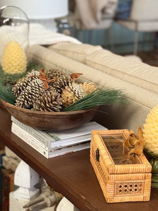 Vintage wood bowl with greenery and bleached pinecones