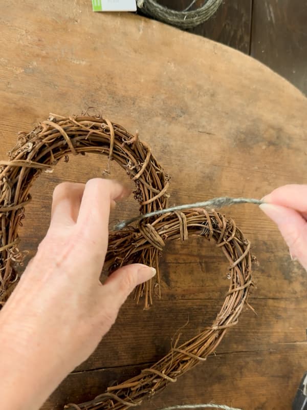 Wrap wire around the grapevine heart wreath to help attach pinecone flowers.  