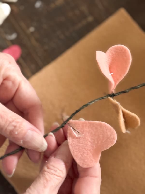adding hot glue to felt hearts to attach to floral wire 